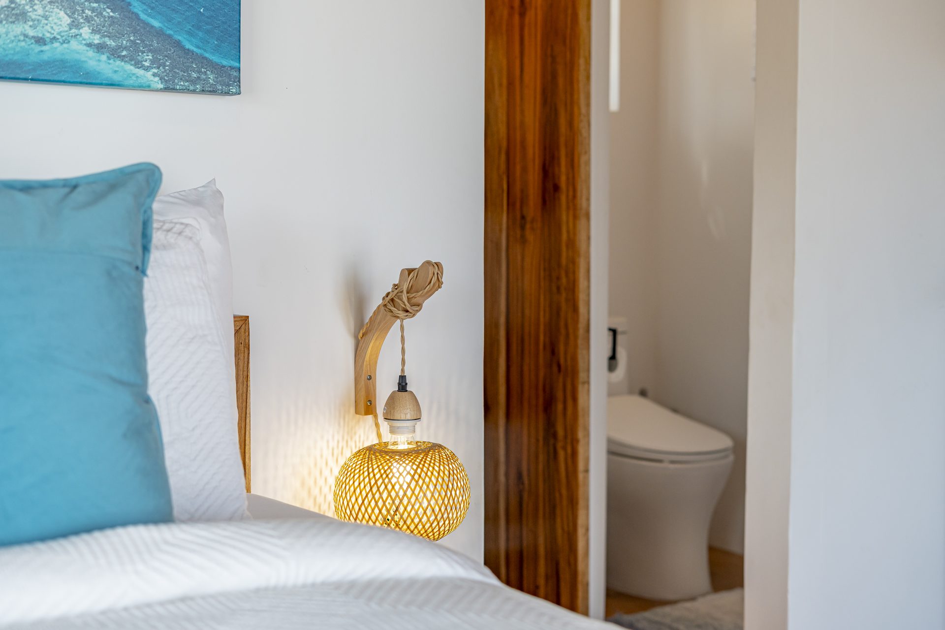 Woven bedside lamp beside the Scuba Room bed