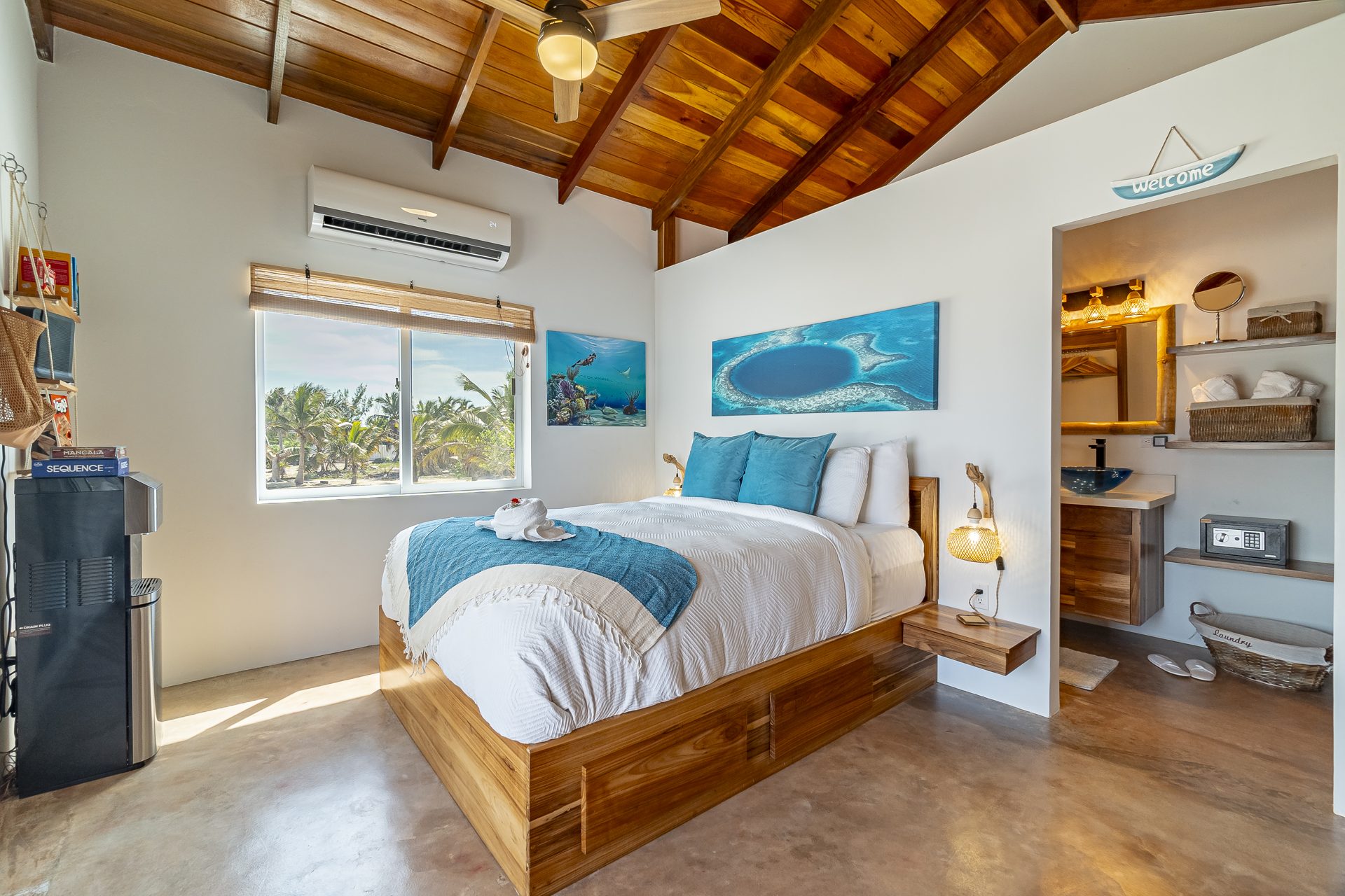 Scuba Room bed under a vaulted wood ceiling with ocean artwork