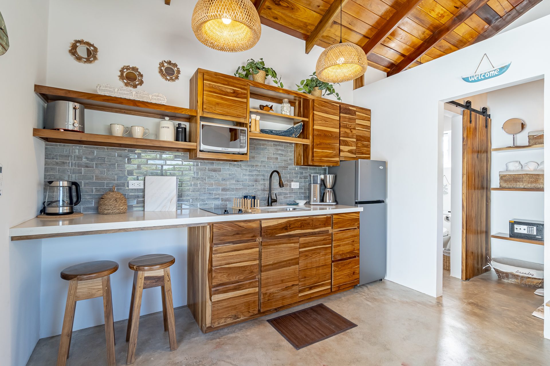 Tarpon Room kitchenette with wood cabinets and breakfast bar stools