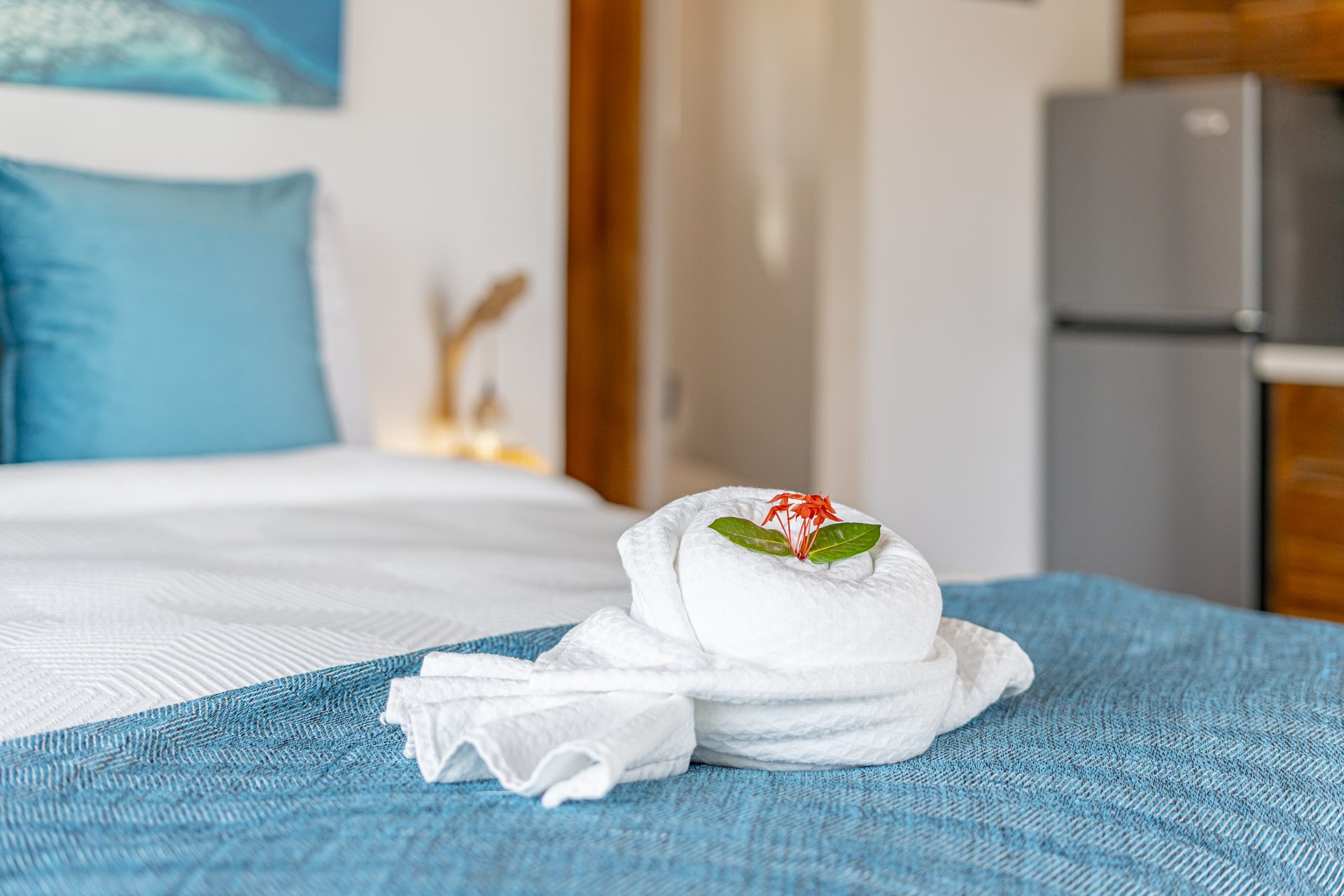 Folded towels with a flower on the Scuba Room bed