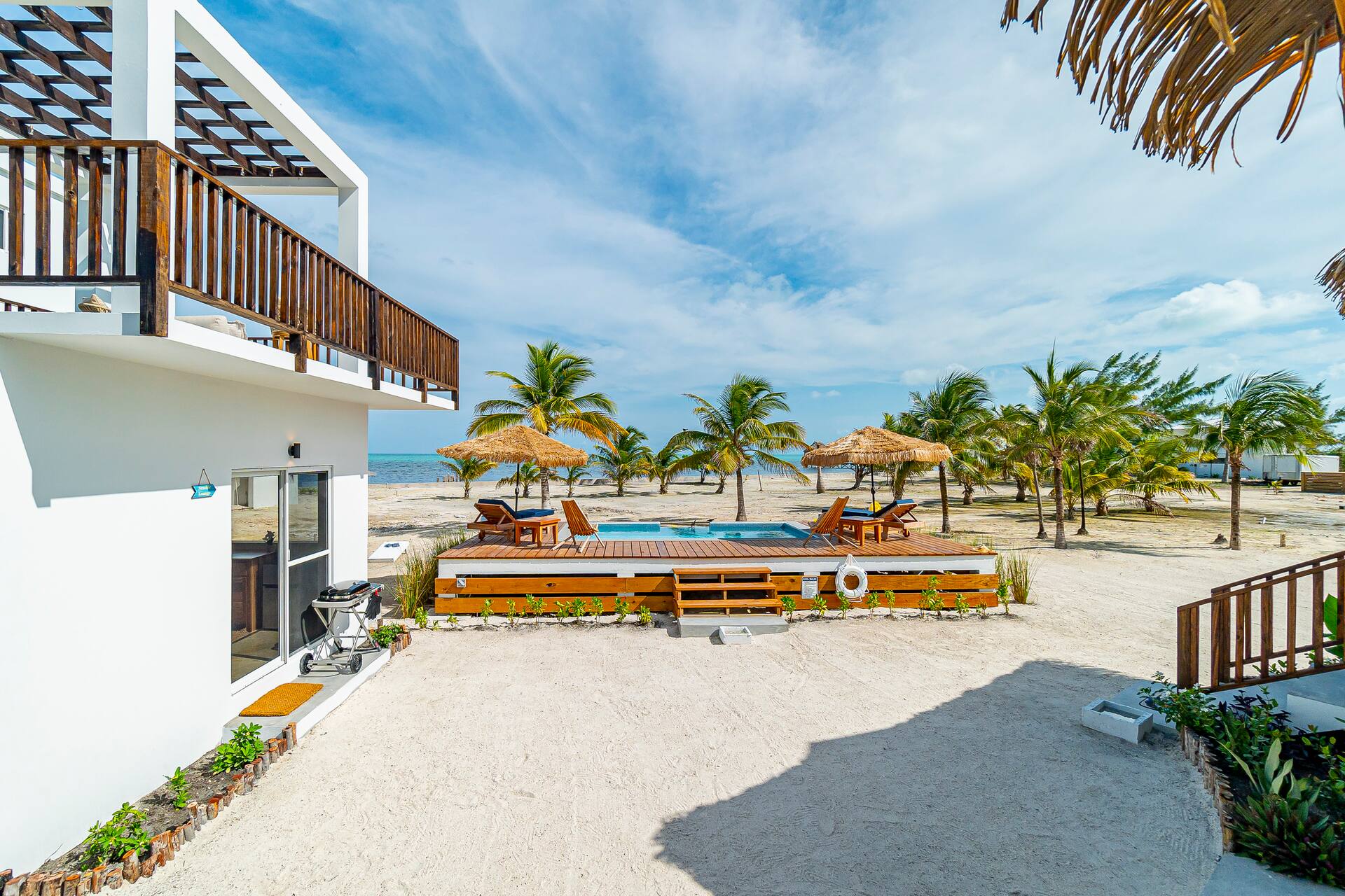 The Seaside Lounge balcony looking over the pool and beach umbrellas